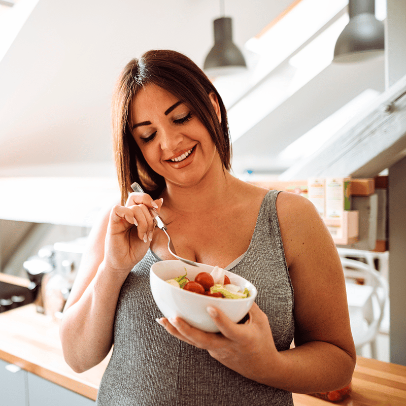 Nutrição na Gestação: Gestante comendo um bowl de frutas